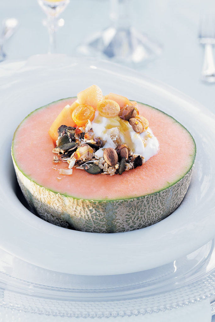 Toasted wheat-free muesli served in a melon with Greek-style yoghurt, gooseberries and honey recipe
