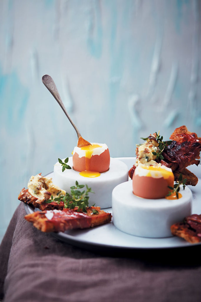 Soft-boiled eggs with prosciutto-wrapped toast soldiers and porcini butter