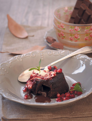 Gooey chocolate cake served with crème fraîche and pomegranates