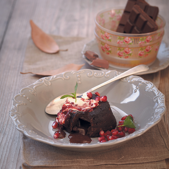 Gooey chocolate cake served with crème fraîche and pomegranates