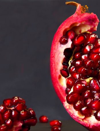 Split open pomegranate to revel ruby red arils