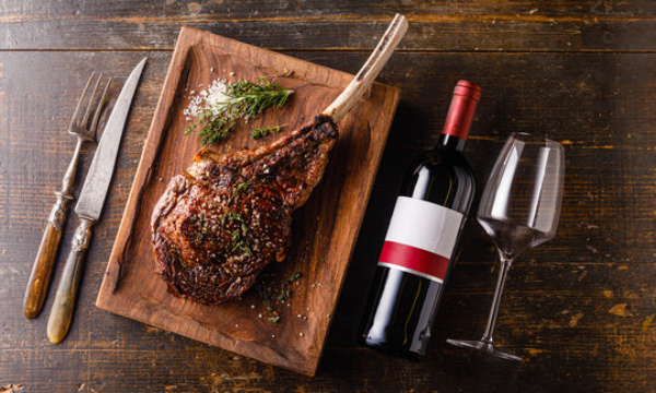 A beautifully cooked tomahawk steak and a bottle of red wine at Butcher Block Hillcrest - Hillcrest Restaurants 