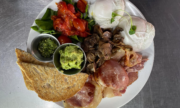A yummy breakfast consisting of poached eggs, relish, mushrooms, bacon and bread by Gofresh Café and Juice Bar
