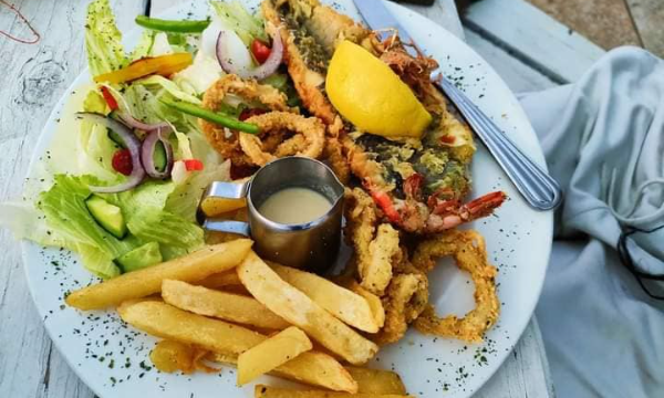 A plate lovely seafood plate with lobster calamari rings, french fries and a green toss salad by Nexdor Restaurant - Vilakazi Street Restaurants