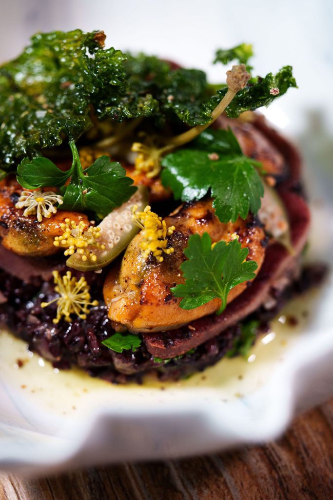 braised beef tongue served with mussels and black rice amid a silky mussel and parsley velouté and topped with kale chicharron and fennel flowers