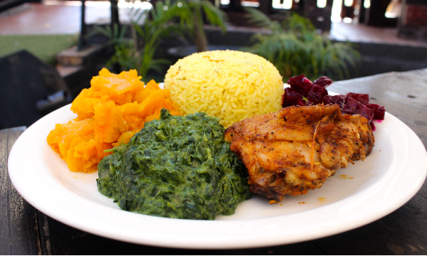 A beautiful plate of yellow rice, pumpkin, spinach and roasted chicken by Sakhumzi Restaurant - Vilakazi Street Restaurants